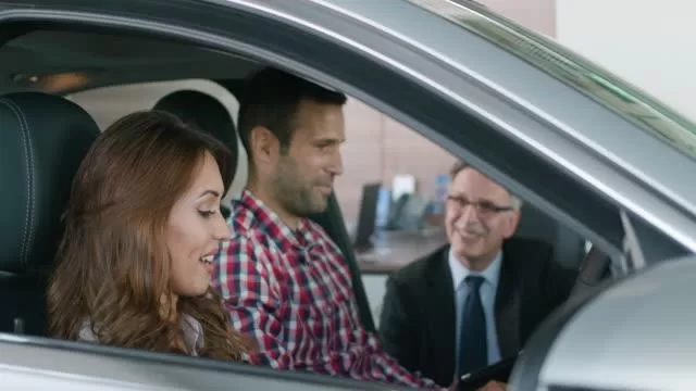 Car salesperson handing keys to a new vehicle owner