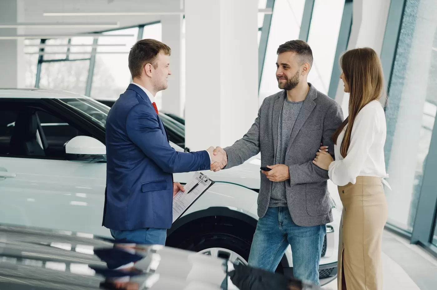 A couple completing their vehicle purchase with a salesperson in the showroom